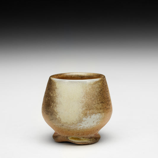 Small ceramic cup with a textured surface on a gradient background